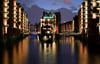 Die Lichter der Speicherstadt spiegeln sich am 26.10.2013 in Hamburg im Wasser im Zusammenfluss von Holländischbrookfleet (l) und Wandrahmsfleet (r) mit Blick auf das Wasserschloss. Am 29. Oktober 2013 jährt sich zum 125. Mal die Einweihung der Speicherstadt. Foto: Angelika Warmuth/dpa +++(c) dpa - Bildfunk+++