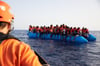  Die von der Seenotrettungsorganisation Sea-Eye herausgegebene Aufnahme zeigt einen Seenotretter, der zu einem Flüchtlingsboot schaut. Die Initiative „Seebrücke“ setzt sich für die Bootsflüchtlinge ein.