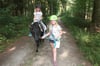  Laura wird von Jana auf Pony Sina durch den Wald geführt.