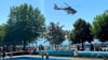  Besucher im Strandbad beobachten, wie der Hubschrauber den mann ins Krankenhaus fliegt.