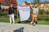 Bad Wurzachs Bürgermeisterin Alexandra Scherer zeigt zusammen mit Dirk Fietkau vom städtischen Bauhof die von Schülern entworfene Flagge.
