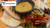 Orientalische Note: Eine Schüssel Hummus mit aufgebackenem Fladenbrot und Salat als Begleitung.