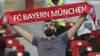  Ein Bayern-Fan hält auf der Tribüne einen Schal