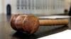 Ein hölzerner Hammer liegt auf der Richterbank in einem Verhandlungssaal eines Gerichts. Foto: Uli Deck/PoOL/dpa/Archivbild