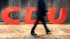 Ein Mann geht an dem CDU-Logo vorbei. Foto: Uli Deck/dpa/Symbolbild