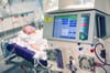 ARCHIV - 09.04.2020, Bayern, München: Ein Patient liegt während seines Aufenthalt im Krankenhaus Großhadern in einem Intensivzimmer an einem Beatmungsgerät und einem Dialysegerät (im Vordergrund). Beatmungsgeräte gelten in der Corona-Krise als esse