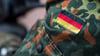 Die Fahne von Deutschland ist auf der Uniform eines Soldaten aufgenäht. Foto: Monika Skolimowska/zb/dpa/Symbolbild