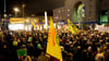 Gegner des Bahnprojektes Stuttgart 21 stehen während einer Montags-Demo vor dem Stuttgarter Hauptbahnhof. Foto: Sebastian Kahnert/dpa