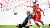 Robert Lewandowski (M) trifft zum 1:0 für Bayern München gegen den Kölner Sebastiaan Bornauw (l). Foto: Matthias Balk