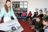 Maya Bernhard, Führerin im Zeppelin Museum, zeigt den Kindern der Grundschule Lindau-Zech ein historisches Foto.