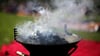 Rauch steigt von einem Grill auf. Foto: Rolf Vennenbernd/Archivbild