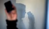 ARCHIV - ILLUSTRATION - Eine Frau telefoniert am 16.12.2013 in Dresden (Sachsen) mit ihrem Mobiltelefon an der Wand zeichnet sich ihr Schatten ab. Beim Enkeltrick gaukeln Betrüger ihren meist betagten Opfern am Telefon vor, ein naher Verwandter - etwa 