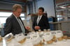 Geschäftsführer Wilhelm Mauß (rechts) zeigt Umweltminister Franz Untersteller die Wasseruhren, die in Ing stetten gefertigt werden.