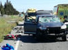 Das Unfallfahrzeug und Rettungskräfte und Fahrzeuge der Ambulanz stehen am Unfallort, an dem ein Auto in eine Gruppe von 15 Radfahrern aus Deutschland gefahren ist.