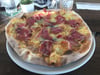 Knuspriger Klassiker: die Pizza mit viel Käse und dicken Schinkenscheiben im Credo in Friedrichshafen.