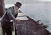 Nachträglich koloriertes Foto des Zeitung lesenden Adolf Hitler an der Mauer der Hinteren Insel südlich des Pulverturms, inszeniert von seinem Hoffotographen Heinrich Hoffmann Ende Juli 1932.
