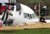 Rettungshelfer stehen am 6.11.2002 am Wrack einer Maschine vom Typ Fokker 50 der Luxair, die bei Niederanven abgestürzt ist.