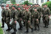 Eine Kompanie von Reservisten marschiert zum Aufstellungsappell vor einer Kaserne.