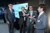 Otto Sälzle (IHK Ulm) überreicht die Trophäe an die Preisträger von Q3-Energieelektronik: Geschäftsführer Joachim Koch, Thomas Neumann und Benjamin Koch (von links).