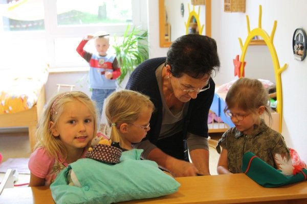 Kinder zeigen Omas und Opas stolz ihren Kindergarten