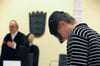 Der wegen Mordes angeklagte 21-Jährige steht mit gesenktem Kopf im Landgericht Ravensburg, während der Vorsitzende Richter Jürgen Hutterer den Raum betritt.