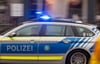 Ein Fahrzeug der bayerischen Polizei fährt mit Blaulicht durch die Innenstadt.