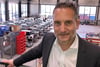 Geschäftsführer Mark-Oliver Daum steht vor einer Reihe FTS, die für das Elektrowerk VW-Emden entwickelt und gebaut worden sind.