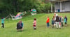 Kinder bei den Riesenseifenblasen auf der Schulwiese.
