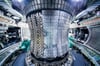 Blick in das Innere des Kernfusionsreaktors in Garching. Etwa dort, wo das Personal arbeitet, schwebt bei Betrieb das hocherhitzte Plasma, in dem Kernfusionen stattfinden.