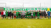 Gruppenfoto vor dem Banner „Hier regiert grün-weiß!‟: Gewonnen hat das Freundschaftsspiel beim TSV Meckenbeuren allerdings der österrichische Erstligist SCR Altach mit 6:0.