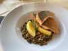 Überzeugendes Fischgericht: Seesaibling mit Kartoffelspalten auf einem Bett aus Berglinsen und Gemüse.