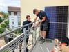 Keno Köttnitz (links) und Nico Rieder von der Häfler Firma Elektro Priebe bringen an einer SWG-Wohnung die Halterung für die Mini-Solaranlage (an der Wand lehnend) an.