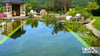 Anblick eines Naturpools mit Blick auf das Wasser, ein Poolhaus und eine Gartenliege im Garten