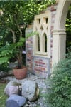 In einem kleinen Garten ermöglicht ein Sichtschutz, in Form einer Steinmauer mit mediterranem Flair, eine gemütliche Atmosphäre.