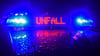 Es spiegeln sich während einer Unfallaufnahme das Blaulicht und der LED – Schriftzug „Unfall“ auf dem nassen Dach eines Polizeistreifenwagens.