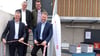 Eröffnungsschnitt des erneuerten Wertstoffhofs auf der Treppe zum Obergeschoss des Wertstoffgebäudes mit Bürgermeister Reinhold Schnell, Abfallwirtschaftsamtsleiter Stefan Stoeßel, Sachgebiets- und Projektleiter Christof Pichler und Landrat Luca Wilhelm Prayon (von links).